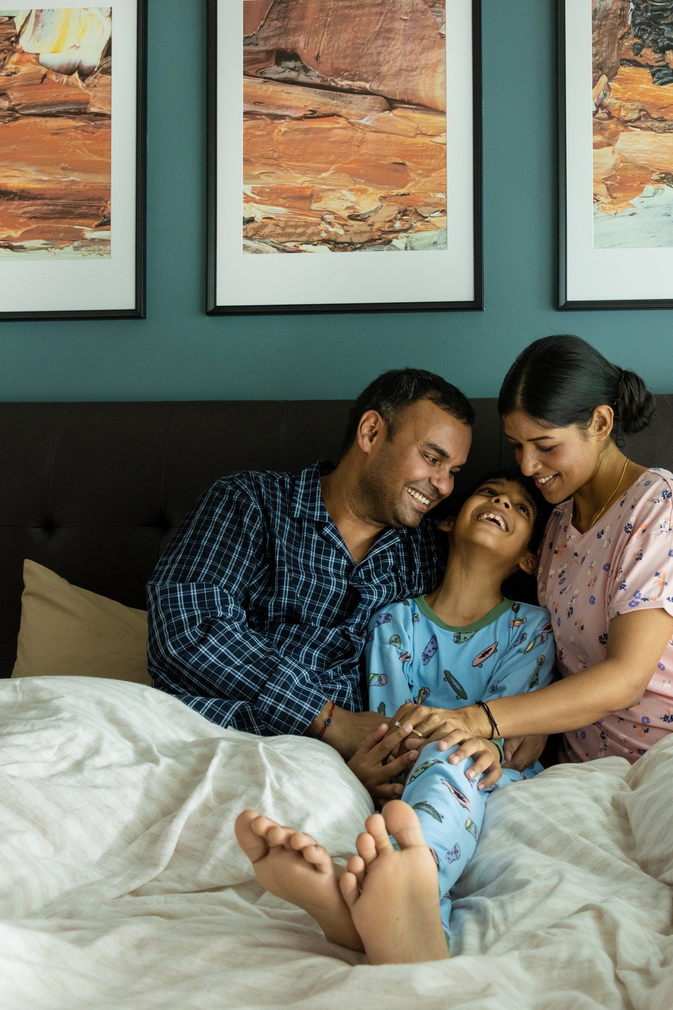 A family sitting together on a bed