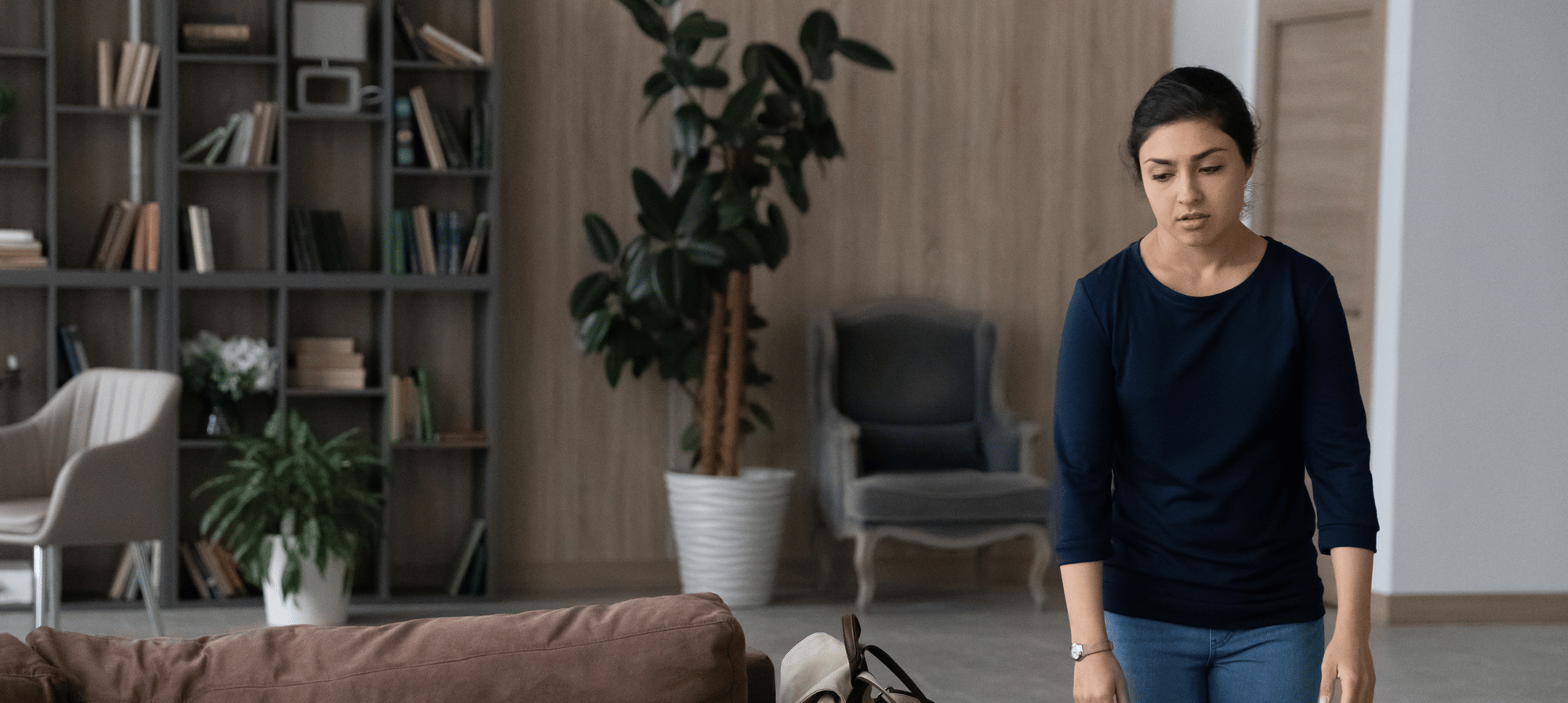  Tired women walks toward a brown sofa
