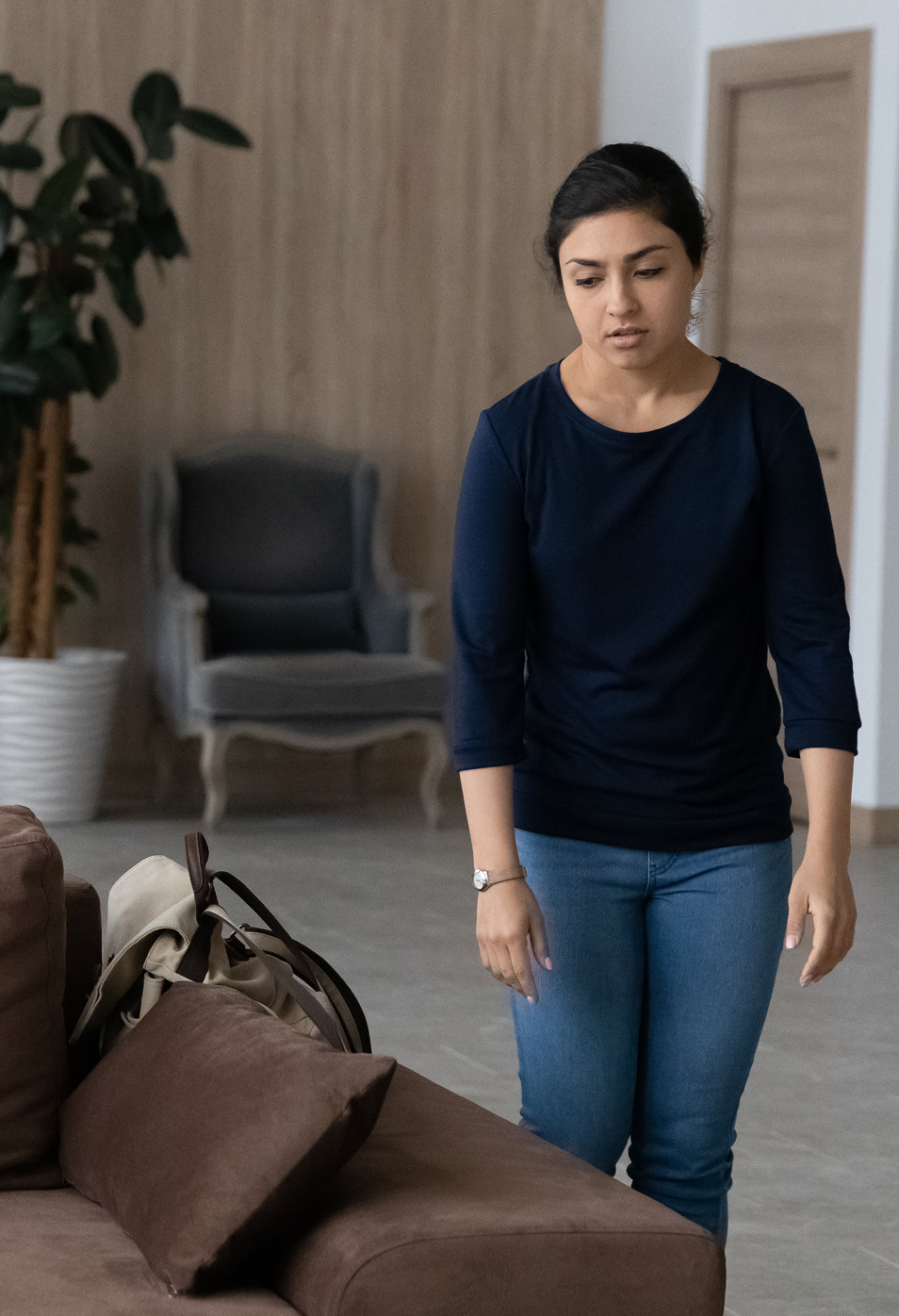  Tired women walks toward a brown sofa