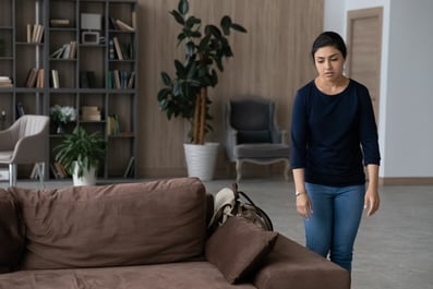 Tired women walks toward a brown sofa