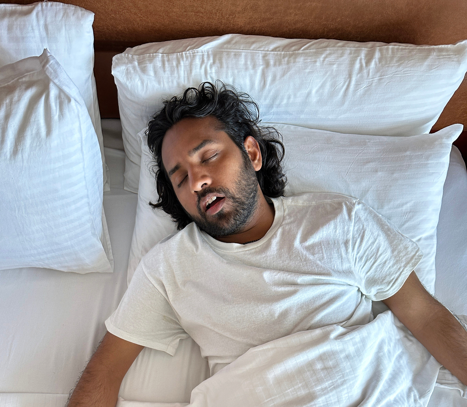 Person sleeping on a bed with mouth open
