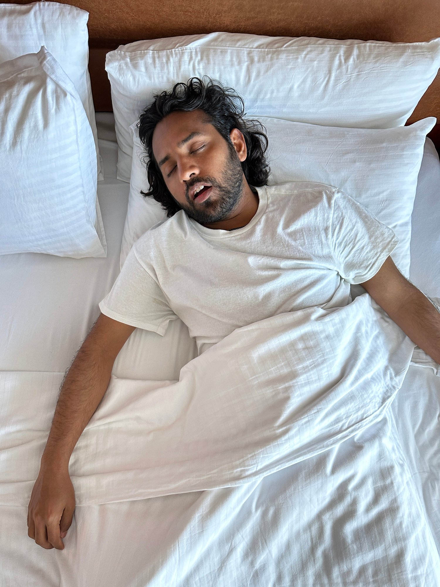 Person sleeping on a bed with mouth open
