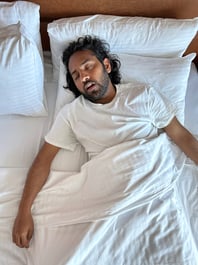 Person sleeping on a bed with mouth open