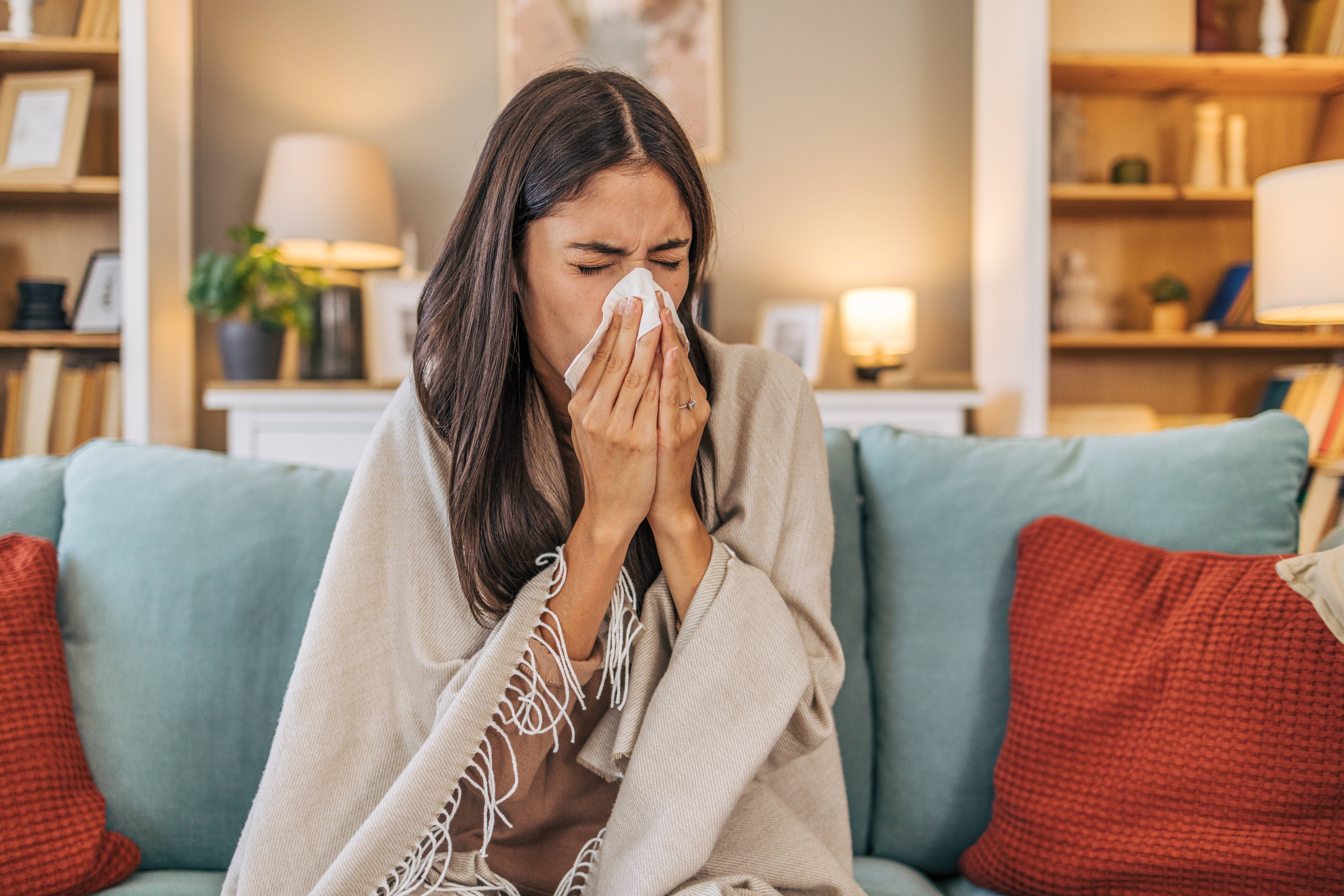 A young woman sitting on a sofa with sinus congestion
