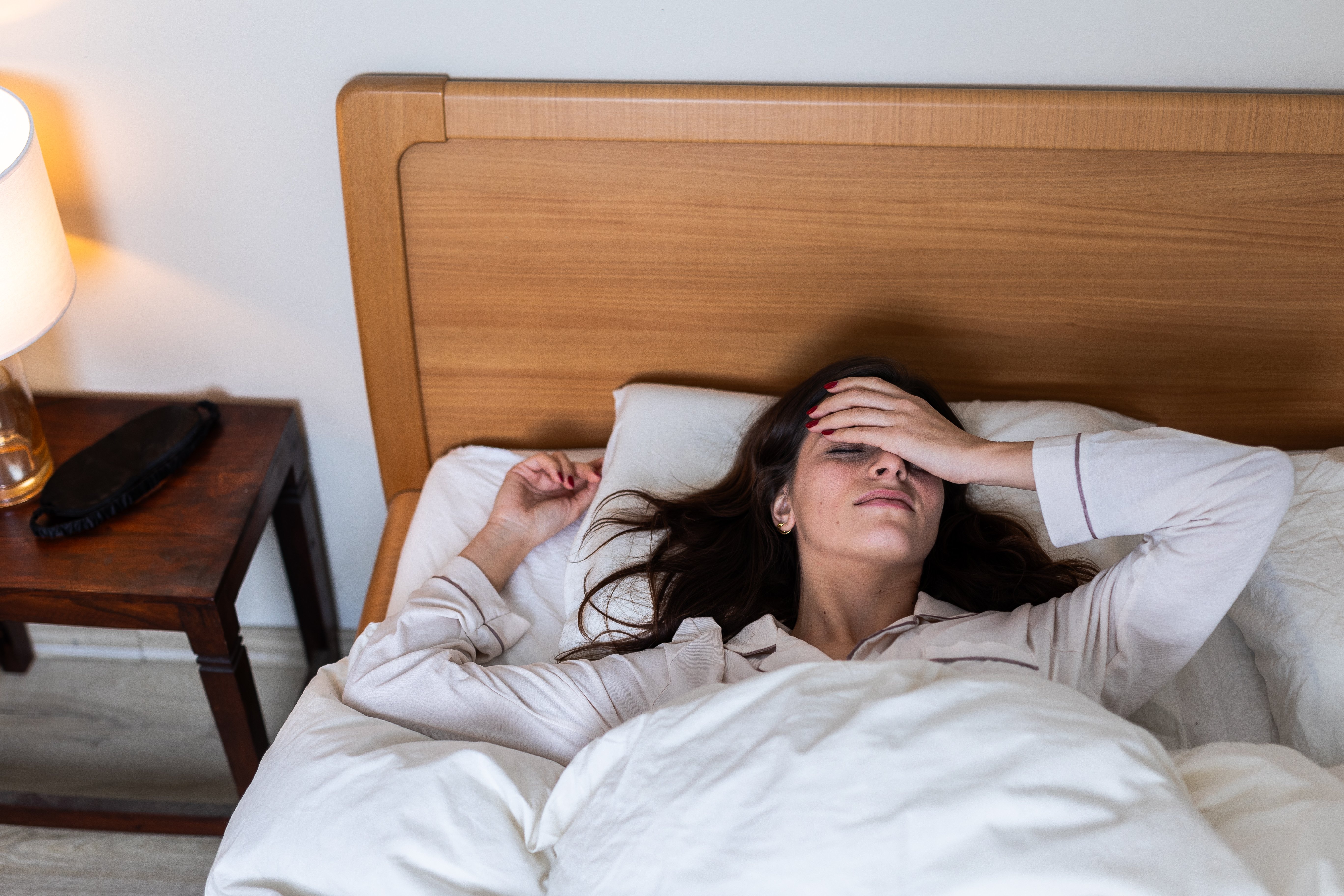 Woman experiencing restless sleep in bed